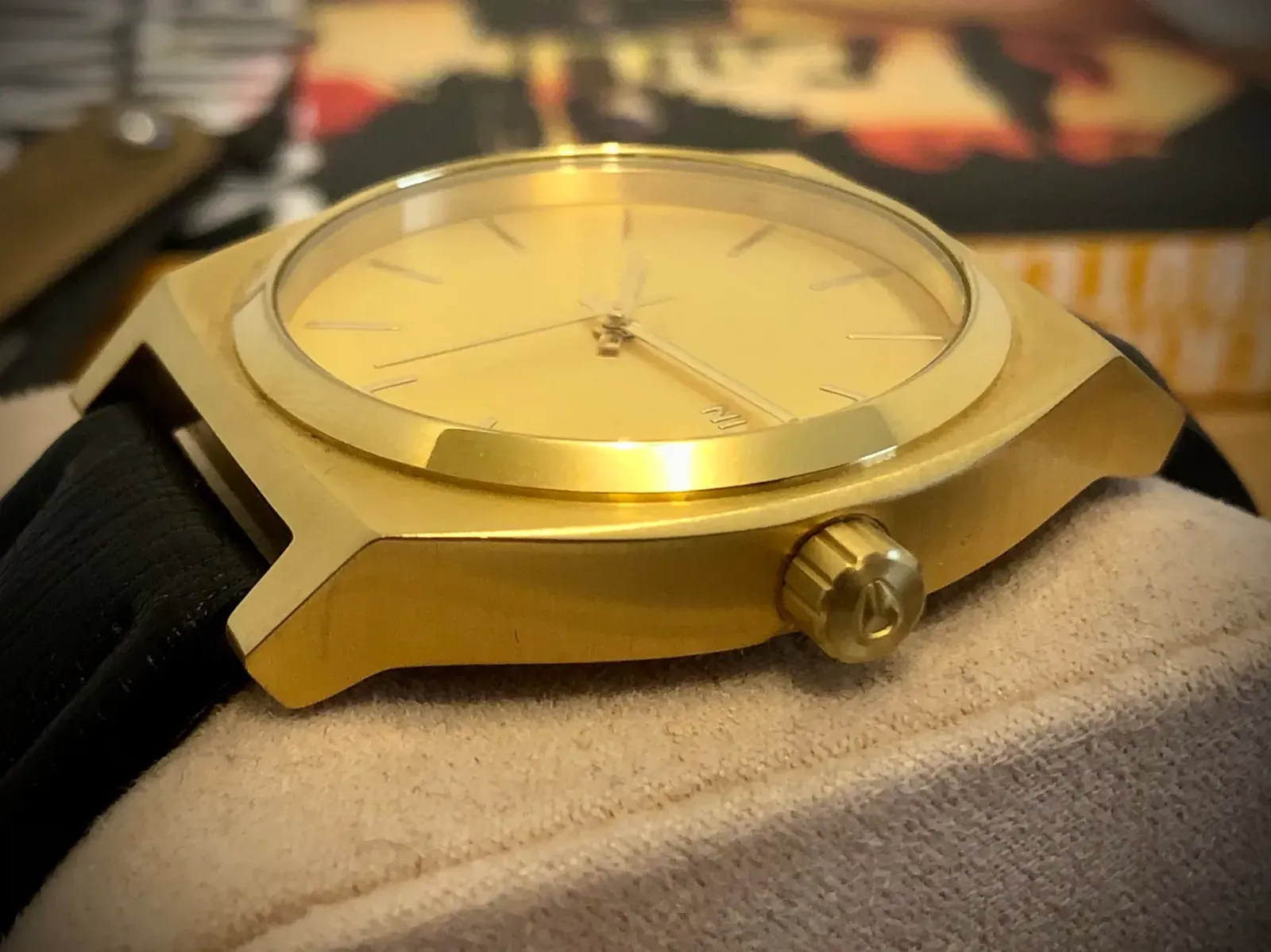 Close-up of the Time Teller's side and its signed, fluted crown, on a watch cushion